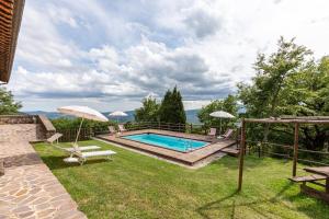 a pool in a yard with a bench and an umbrella at Masseria del bosco Palazzone in Chianciano Terme