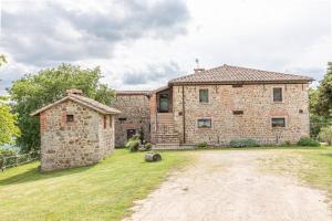a large stone house with a grass yard at Masseria del bosco Palazzone in Chianciano Terme