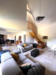 a living room with two couches and a staircase at L'annexe in Plumelec