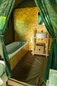 ein Badezimmer mit Badewanne und Waschbecken in der Unterkunft Safari Glamping Portugal Flamingo in Ventosa