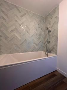 a bath tub in a bathroom with a tile wall at L'annexe - gîte 6 personnes a 25 minutes de Vannes in Plumelec +16 photos