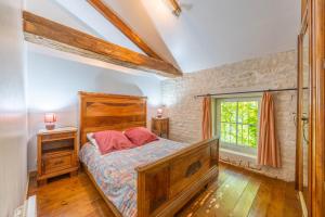 1 dormitorio con cama de madera y ventana en Le Colombier Gites, en Surgères 37 fotos más