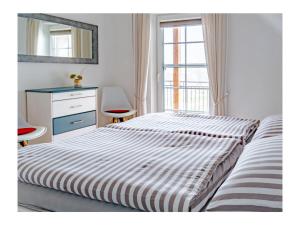 KrumminにあるFerienhaus Familienkoje Hannahのベッドとドレッサーと窓のある寝室