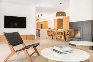 a living room with a chair and a table with books at Melodie home Menorca in Sa Caleta