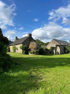 an old stone house in a field of grass at L'annexe in Plumelec