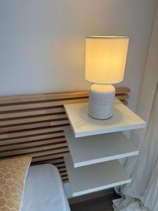 a lamp on a nightstand next to a bed at Casa Eveline in Punta Prima +89 photos