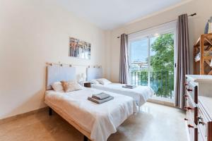 ラ・カラ・デ・ミハスにあるLa Noria Golf Resortの大きな窓のある部屋にベッドが2つある +15枚の写真