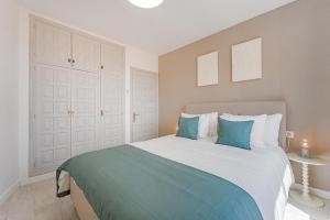 een slaapkamer met een groot bed met blauwe kussens bij Drilasol 1 Bed Apartment in Puerto de Santiago