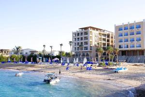 a boat in the water on a beach with buildings at Juliana Beach Elite Queen T Collection in Hurghada