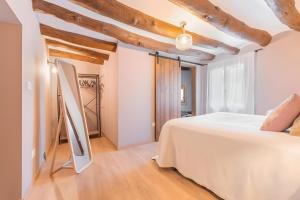 a bedroom with a white bed and wooden ceilings at Casa Rural El Ahora in Berge