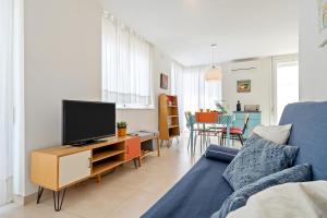 een woonkamer met een blauwe bank en een tv bij Apartamento Sf2 in L'Ametlla de Mar