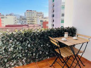 a table and chair on a balcony with a plant at Jolie appt avec Balcon - Hypercentre, proche Medina et Plage in Tangier