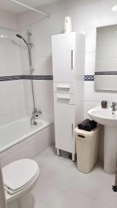 a white bathroom with a toilet and a sink at 2 Bedroom Penthouse Best Sea Views in Manilva