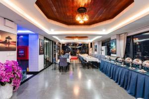 un comedor con mesas, sillas y flores en Jason Residencia One Hotel, en Phnom Penh