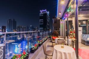 Un balcón con mesas y sillas y un perfil urbano en Jason Residencia One Hotel, en Phnom Penh