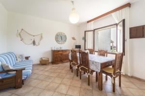 une salle à manger avec une table, des chaises et un canapé dans l'établissement Stintino sea front apartments A, à Stintino 21 autres photos