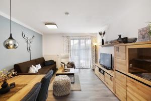 オーバーアウドルフにあるFewo Brünnstein - Nr 2, Pool,Saunaのソファとテレビのあるリビングルーム +10枚の写真