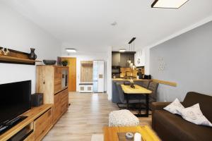 オーバーアウドルフにあるFewo Brünnstein - Nr 2, Pool,Saunaのソファとキッチンのあるリビングルーム