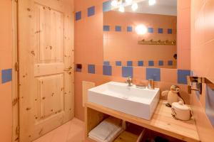 ein Badezimmer mit einem weißen Waschbecken und einer Tür in der Unterkunft Alba Villa Nordica in Livigno + 20 Fotos