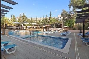 a swimming pool with lounge chairs and a resort at Apartamento Balaia Praia in Albufeira