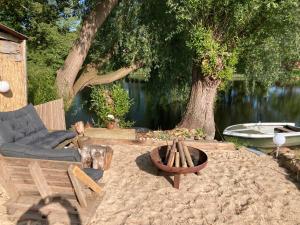 a patio with a fire pit and a chair and a tree at Monteurwohnung Schulze in Bad Bodenteich