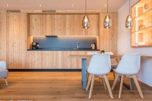 a kitchen with a table and white chairs at Aura Chalets - Nr 4 in Castelrotto +21 photos
