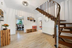 a living room with a staircase and a dining room at Ferienhaus Kribbikrabba Butjadingen in Butjadingen