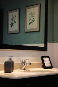 a bathroom sink with a mirror and a tablet on it at El Tercer Piso in Puente la Reina