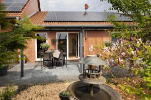 a garden with a bird feeder in front of a house at Ferienhaus Am Waldrand in Wietze