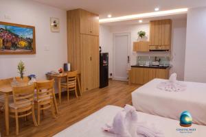 een kamer met 2 bedden, een tafel en een keuken bij Coastal Nest - Steps to Sand in Da Nang