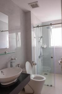 een badkamer met toilet, wastafel en douche bij Coastal Nest - Steps to Sand in Da Nang