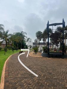 Ein Hund liegt auf einer Ziegelstraße in einem Park in der Unterkunft Madeley House Unit 1 near Oliver Tambo Airport in Boksburg