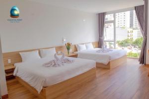 twee bedden in een hotelkamer met zwanen erop bij Coastal Nest - Steps to Sand in Da Nang +24 foto's