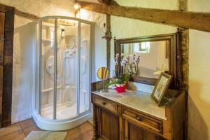 a bathroom with a shower and a vanity with a mirror at Maison De Charme Avec Jacuzzi in Arcangues