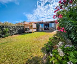 a house with a yard with flowers and plants at Villa Maffy in Baja Sardinia