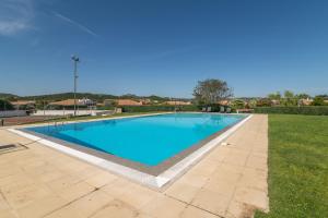 a large swimming pool in a yard with grass at Villa Maffy in Baja Sardinia