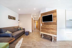 リフィアーノにあるChalet Ebnerhofのソファと壁掛けテレビのあるリビングルーム