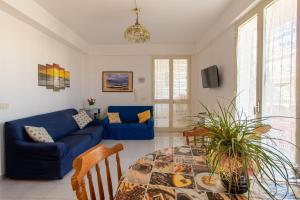 a living room with a blue couch and a table at Casa Riviera in Donnalucata