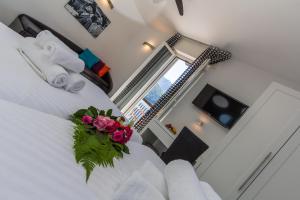 a bedroom with a white bed with flowers on it at Hotel Riviera in Melide