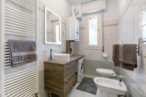 デセンツァーノ・デル・ガルダにあるIl Sire - Casa Vacanzaの洗面台とトイレを備えた白いバスルーム +15枚の写真