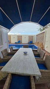 ein Esszimmer mit einem Holztisch und Stühlen in der Unterkunft dar saoussen in Triffa