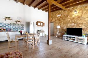 Una gran sala de estar con una mesa y un televisor. en El Algarrobero, en Santa Lucía
