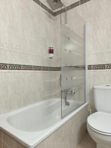 a bathroom with a bath tub and a toilet at Las Palmeras in Matalascañas