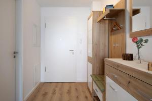 a kitchen with white walls and a wooden floor at Ferienwohnung Münster, sehr zentral in Freiburg im Breisgau +24 photos