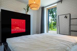 LindauにあるLa casa nel verdeの大きなベッドと大きな窓のある寝室