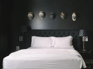 1 dormitorio con 1 cama blanca grande con paredes negras en Aethos Milan, en Milán