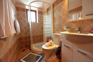 Un baño con inodoro, ducha y lavabo. en Villa Casa Bianca Purple Apartment, en Bogdanátika 29 fotos más