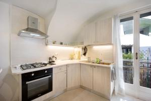 Una cocina con estufa, fregadero y ventana. en Dolceacqua, en Dolceacqua 11 fotos más