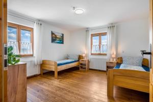 une chambre avec deux lits et deux fenêtres dans l'établissement Ferienwohnung mit Bergblick, à Edling