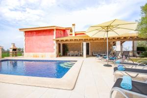 une piscine avec des chaises et un parasol à côté d'une maison dans l'établissement Can Cuixa, à Santa Margarita